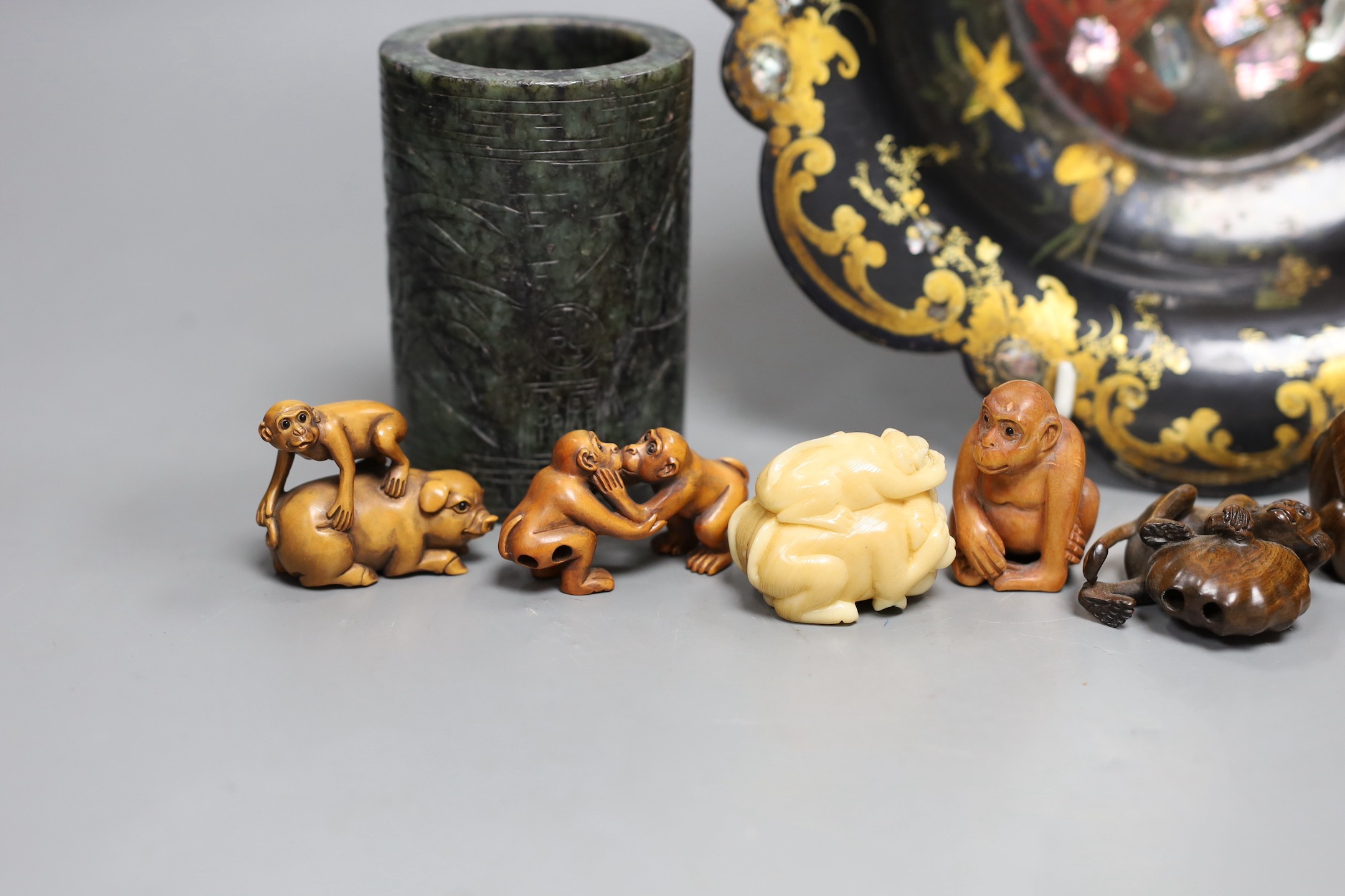 A Chinese soapstone brush pot and a group of netsuke and a papier mache dish, 26cms diameter
